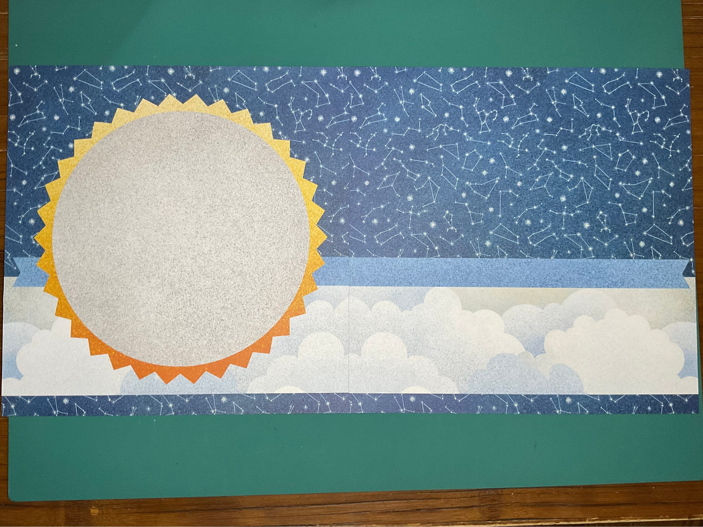 Celestial-themed scrapbooking kit on a green surface